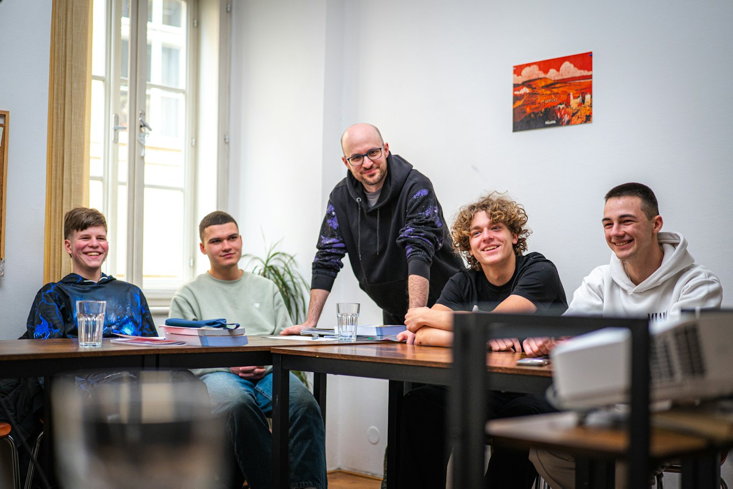Teacher guiding young men in a classroom discussion.